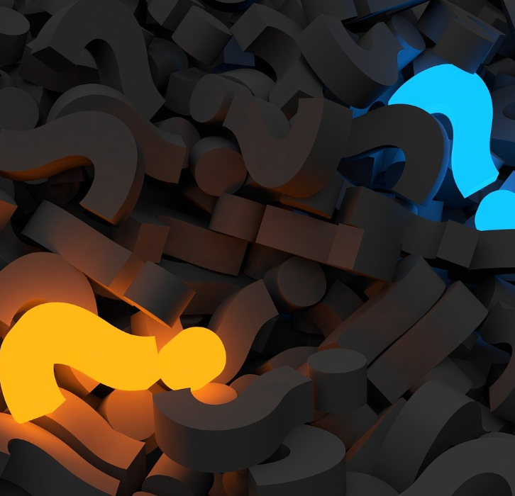 pile of gray question marks with one lighted up in orangish yellow and another in blue